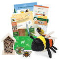 Educational bee-themed items including a plush bee, insect hotel, and books on a white background